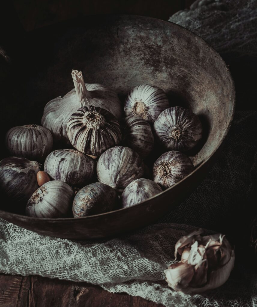 Eine ungewöhnliche Sorte Knoblauch. Rare Breed Kühe. Foto von <a href="https://unsplash.com/de/@ling_hua?utm_source=unsplash&utm_medium=referral&utm_content=creditCopyText">ling hua</a> auf <a href="https://unsplash.com/de/fotos/braune-und-weisse-runde-fruchte-in-schwarzer-schale-HhfL-eoLaP0?utm_source=unsplash&utm_medium=referral&utm_content=creditCopyText">Unsplash</a>
